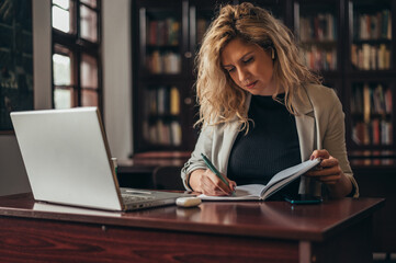 Businesswoman working in her office and using a laptop