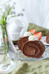 Chocolate Swiss Roll Cake with Chocolate cream filling and Strawberry set on cafe table.
