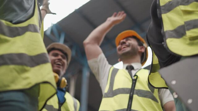 group of diversity warehouse worker meeting and joining hands together in industry factory . eastern manager, african american clerk woman , asian man . teamwork of multiethnic  cooperation success