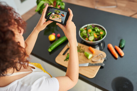 Woman taking a photo with the mobile to a salad