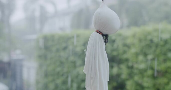 Handmade Cute Japan Doll Teru teru bouzu hanging against rainy day with natural background
