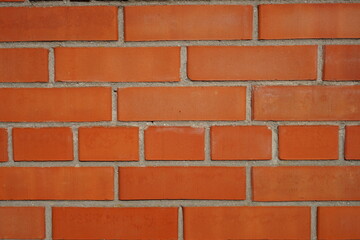 Background part of orange brick wall with grey seams