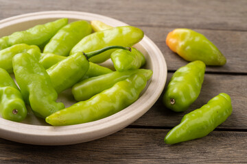 Green cheiro (scent/smell) pepper on a plate over wooden table