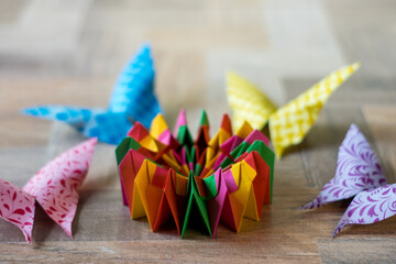 colorful modular origami in the shape of a kaleidoscope with colorful butterflies on its sides
