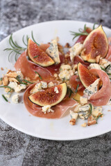 Fototapeta na wymiar Figs with Parma ham with blue cheese, nuts and honey