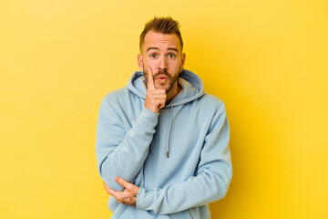 Young tattooed caucasian man isolated on yellow background having some great idea, concept of creativity.