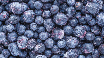 Frozen blueberries background.Water drops on ripe sweet blueberry. Fresh blueberries background with copy space for your text. Vegan and vegetarian concept.Texture blueberry berries close up