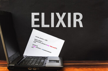 Elixir Programming Language. Word Elixir on wall and laptop 