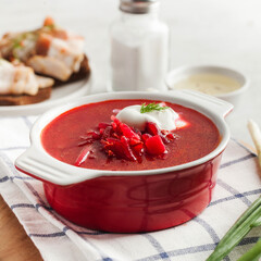 Delicious fresh red borscht, dark bread with lard and salt n kitchen table. 