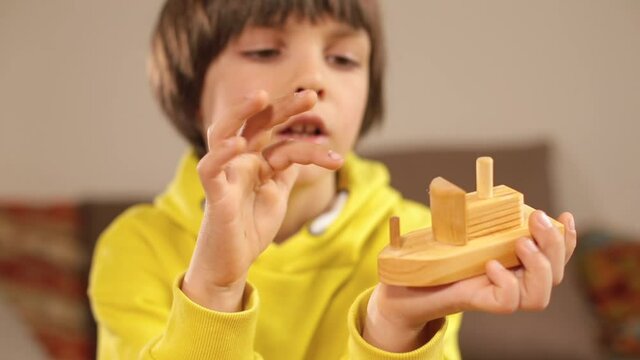 Tactile examination of a wooden object by a psychologist. The child touches, tells the feelings. Relaxation of the psyche in communication.