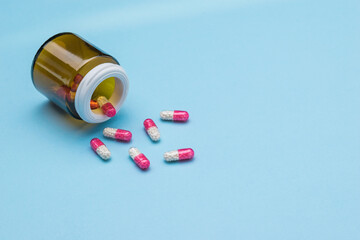 Capsules with the drug are poured out of a glass jar.