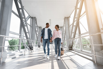 Portrait Of Happy Black Couple Travelling Together, Walking With Suitcases In Airport