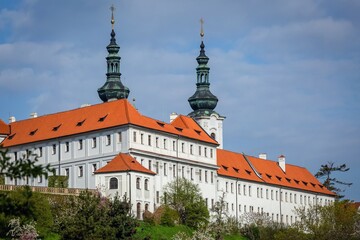 Prague, Czech Republic - May 3 2021: View of the Strahov monastery with white facade and red roof...