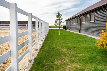 white wooden fence. Country Equestrian Club. ground for walking, exercise routine and working horses outdoors.