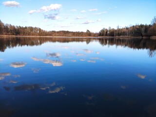 Crystal clear lake reflecting lightly clouded blue sky