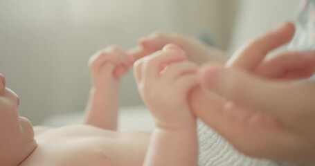 Holding newborns hand in Slow Motion . Happy Family Mother and her Newborn Baby together. Maternity concept. Parenthood. Motherhood.