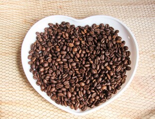 coffee beans on a white heart-shaped plate
