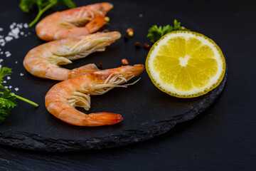 Shrimps with spices, salt, lemon and parsley on a slate board
