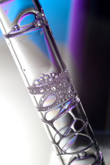 Obraz premium Cosmetic pipette with drops of transparent liquid and a jar, close-up on a colored background.