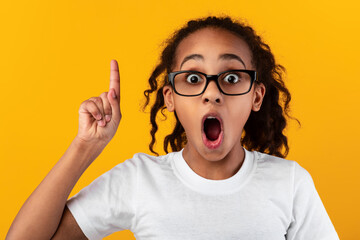 Excited black girl has great idea and points up