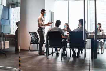 Colleagues having meeting in boardroom, businessman giving speech