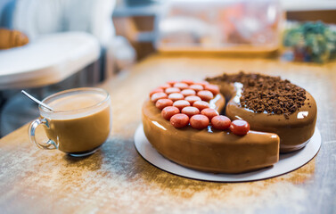 Wonderful delicious chocolate cake in the shape of Yin-Yang in a home kitchen on a wooden table and a transparent cup with coffee