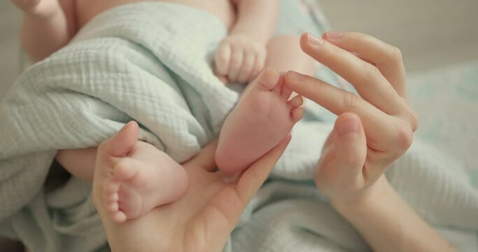 Tiny Newborn Baby's feet in mother hands. Mom and her Child. Happy Family concept.
