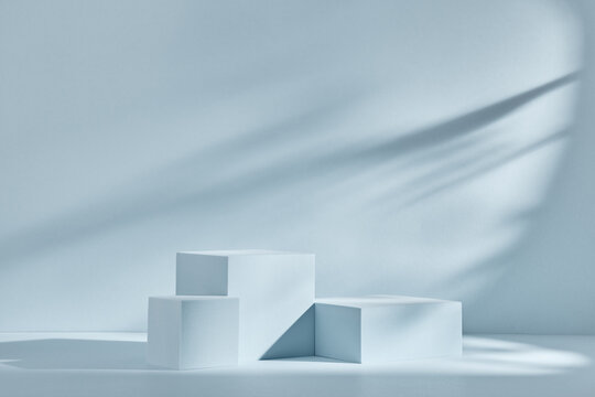 Blue background for product presentation with shadows and light. Empty podiums. Mockup.
