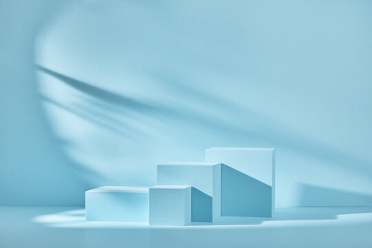 Blue background for product presentation with shadows and light. Empty podiums. Mockup.