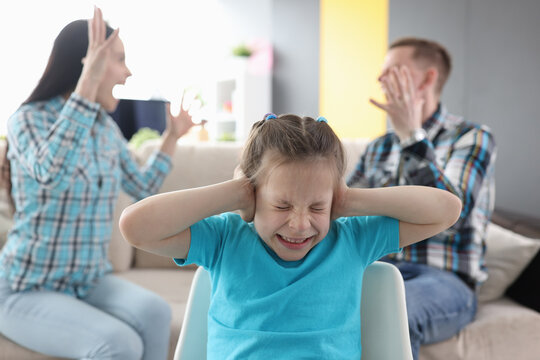 Llittle girl in fear closes her ears so as not to hear her parents swear