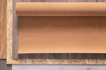 Laminate floor and cork roll on wood osb background texture. Wooden laminate floor plank with copy space