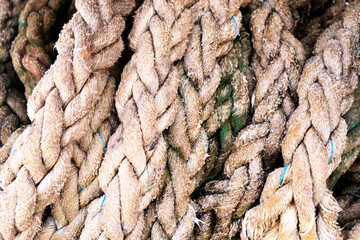 Close-up of an old frayed boat rope as background. Texture of heavy duty cable. Use for marine background. Background of rope