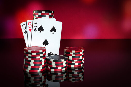 Poker cards with three of a kind or set combination. Close-up of playing cards and chips in poker club. Free advertising space