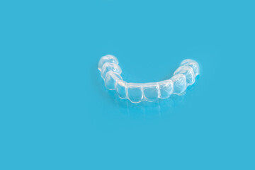 close-up of Silicone Night Mouth Guard for Teeth Clenching Grinding Dental Bite Sleep Aid on a blue background, concept dental services, remedy for grinding teeth, oral care