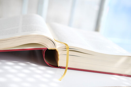 Close-up Of Thick Paper Book In Dark Red Cover, Family Bible, Concept Eternal Values, Education, Studying Sacred Christian Texts, Retro Technology