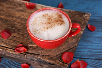 Cinnamon coffee in a red mug and red ranunculus