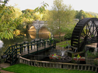 Old water mill by bridge over canal in the town of Bath in England