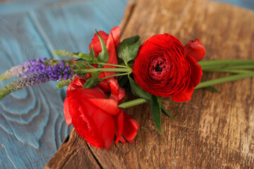 Red ranunculus on wooden board