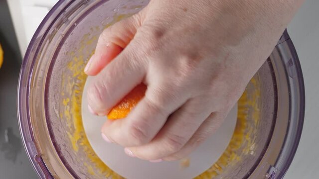Woman preparing orange juice in juicer. Squeezing procces. Top view