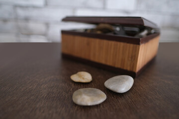 wooden brown box for storing the sacred objects of the fortuneteller, flat stones for...
