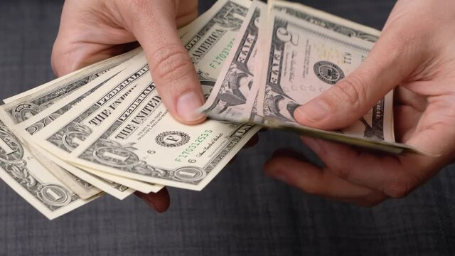 Woman's hands counting cash US dollar bills banknotes in her hands. View from above. 4k video