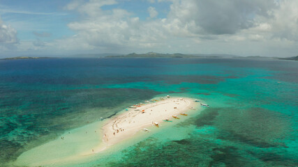 Beautiful beach on tropical island surrounded by coral reef, sandy bar with tourists, top view. Naked Island, Siargao.