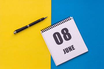 June 8th. Day 8 of month, calendar date. Notebook with a spiral and pen lies on a yellow-blue background
