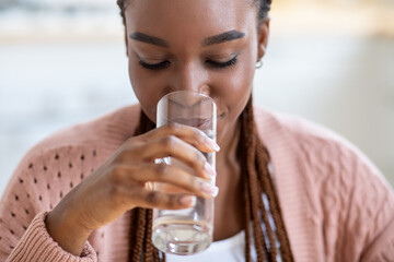 Refreshing Drink. Beautiful Young Black Lady Drinking Water From Glass At Home