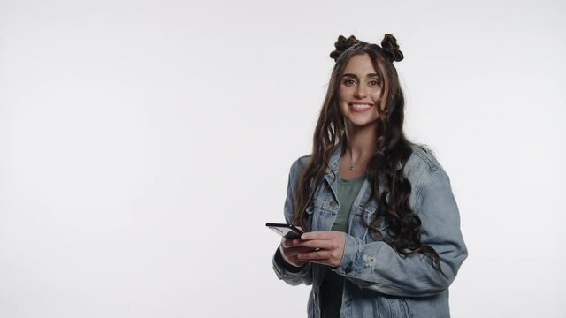 Happy young woman uses a smartphone