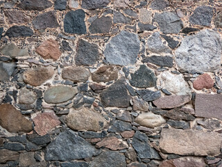 Fragment of the wall of an old house made of stones of different sizes