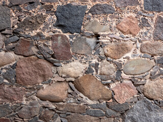 Fragment of the wall of an old house made of stones of different sizes