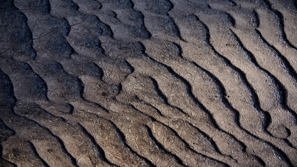 Gefrorener Sandboden in Wellen, Muster und Struktur mit Eisschicht