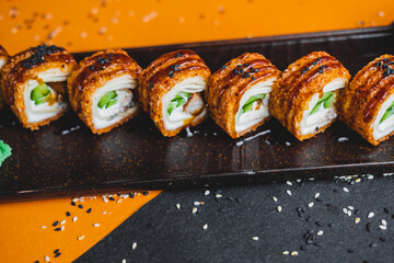 Rolls with salmon and eel on a black plate in a beautiful presentation