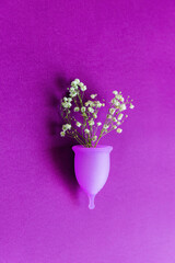 Menstrual cup with white flowers on purple background
Conceptual feminine hygiene, body care